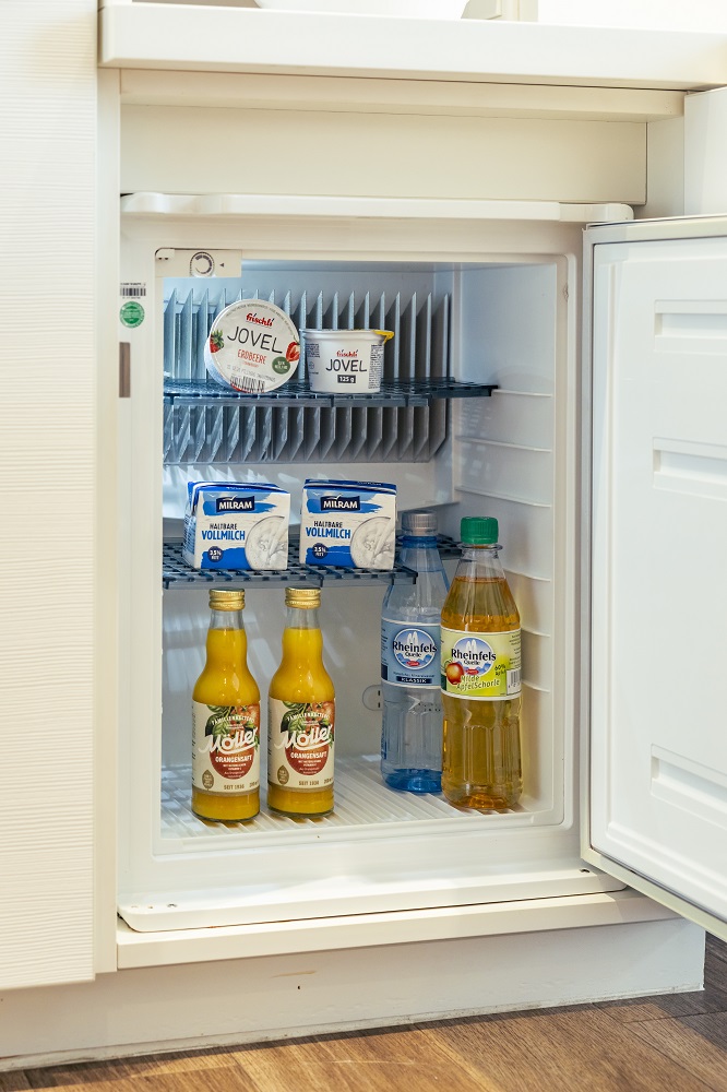 Mit Saft, Wasser, Apfelschorle, Milch und Joghurt gefüllter Kühlschrank.